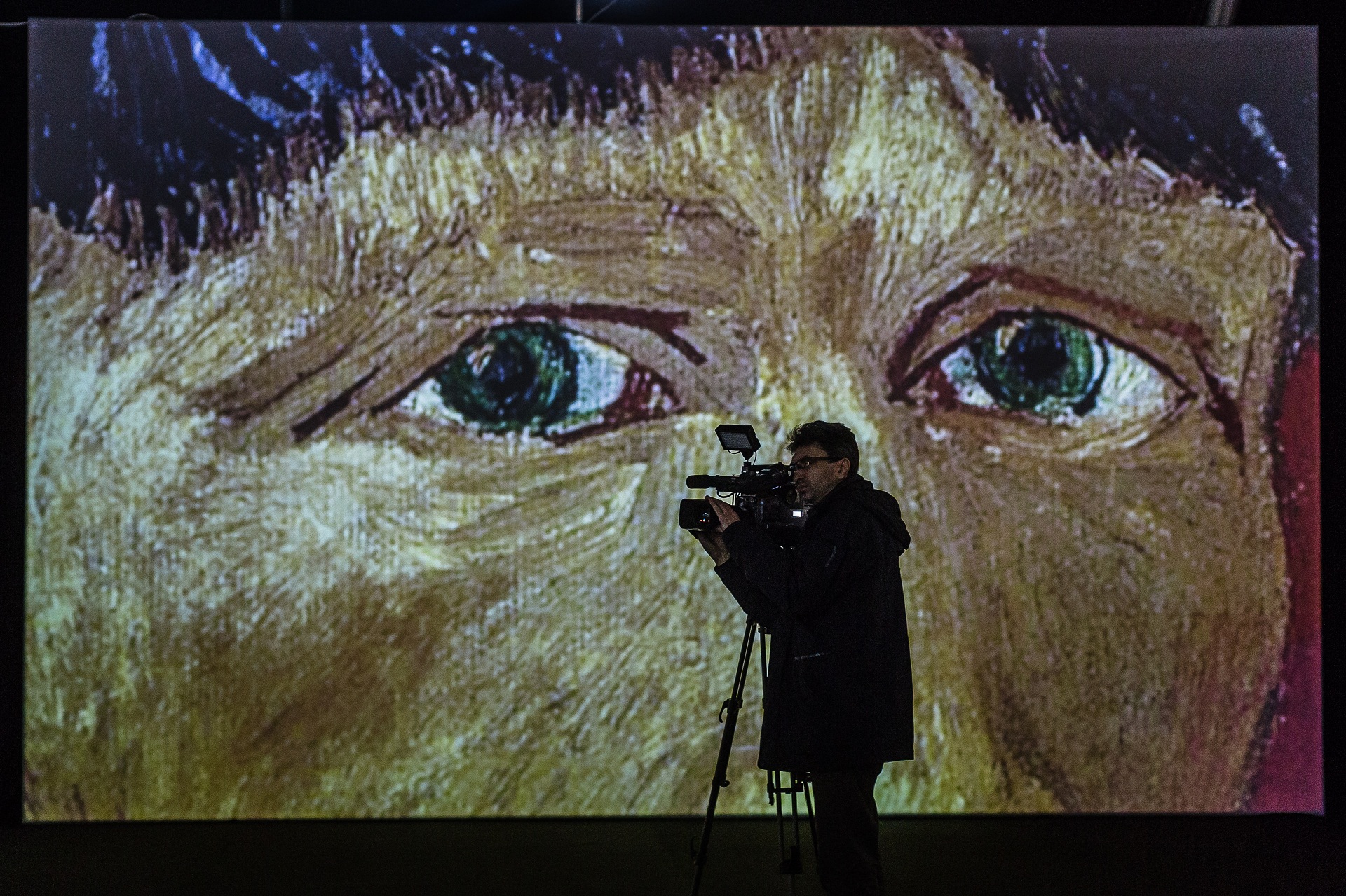 A cameraman films in front of a screen displaying part of a painting by Dutch artist Vincent Van Gogh during the official opening of the "Van Gogh Alive" multimedia exhibition in Warsaw, on November 13, 2015. AFP PHOTO / WOJTEK RADWANSKI
RESTRICTED TO EDITORIAL USE - MANDATORY MENTION OF THE EXHIBITION UPON PUBLICATION, TO ILLUSTRATE THE EVENT AS SPECIFIED IN THE CAPTION (Photo by WOJTEK RADWANSKI / AFP)